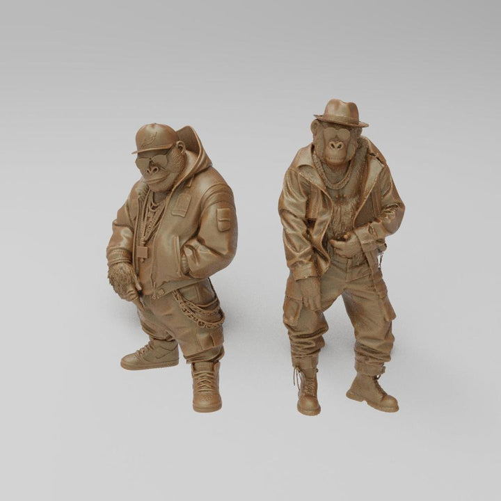Two unpainted terracotta resin 3D-printed monkey figures in hip-hop streetwear, including hoodies, hats, and chains.