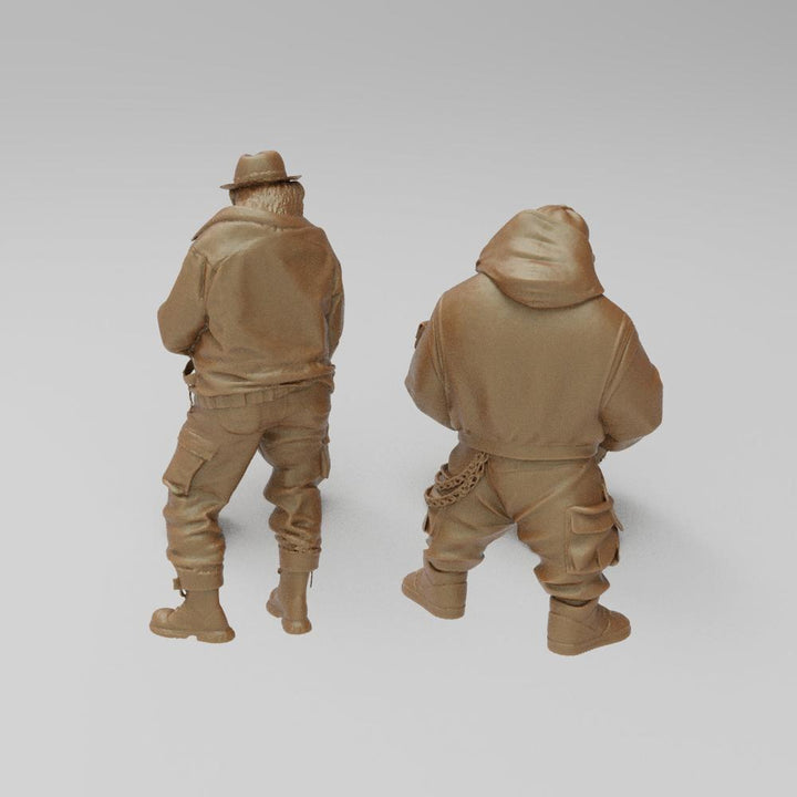 Two unpainted terracotta resin 3D-printed monkey figures in hip hop streetwear, viewed from behind.