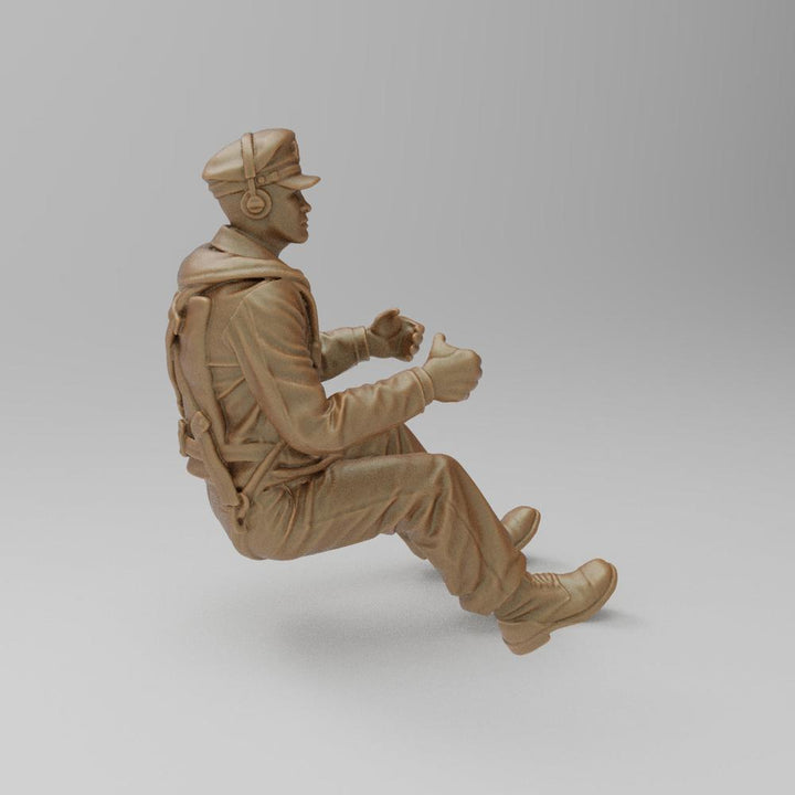 Unpainted terracotta-colored 3D resin model of a seated WW2 bomber pilot wearing a cap, headset, and flight gear.