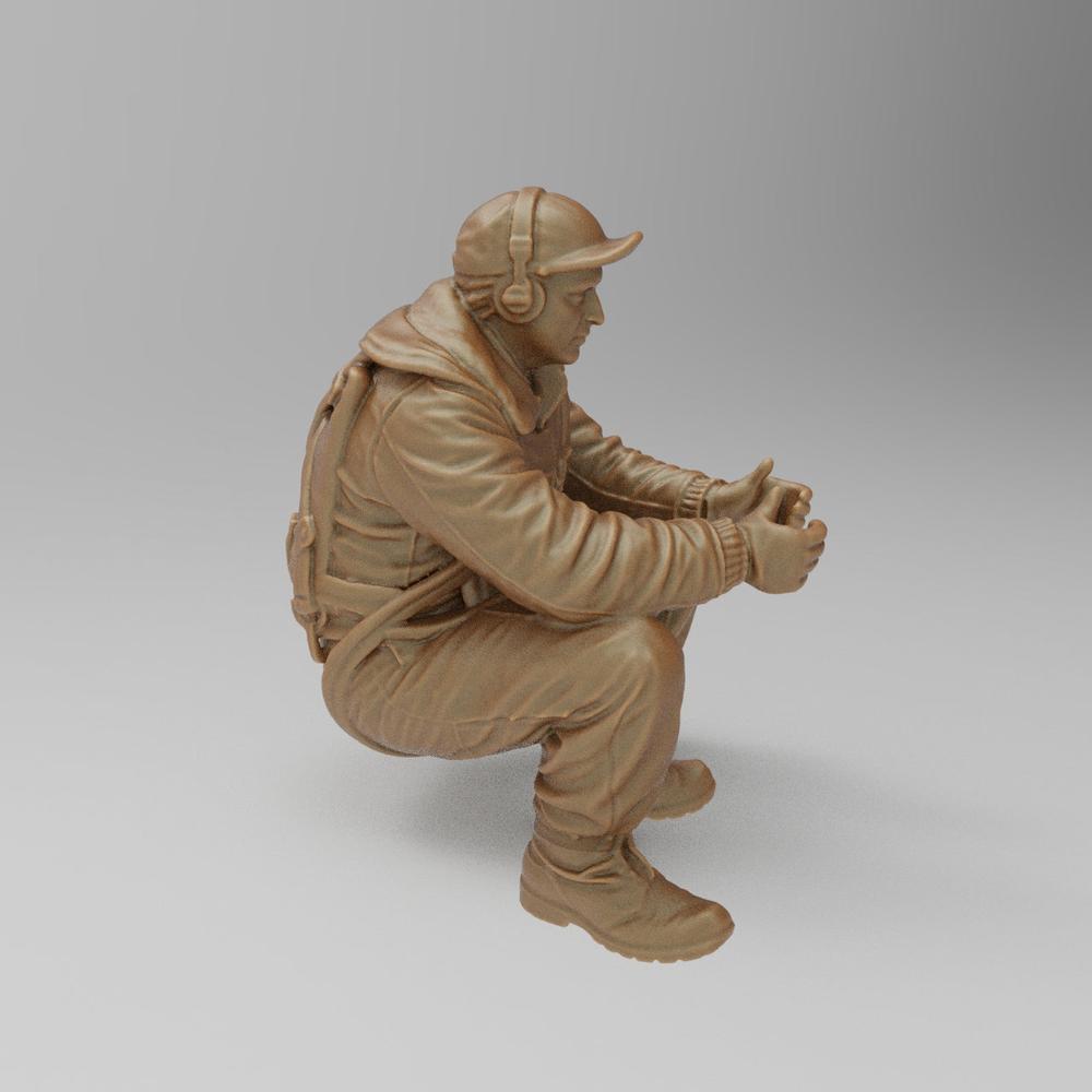 Unpainted 3D printed resin miniature of a WW2 bomber tail gunner in a seated position, wearing flight gear and headset.