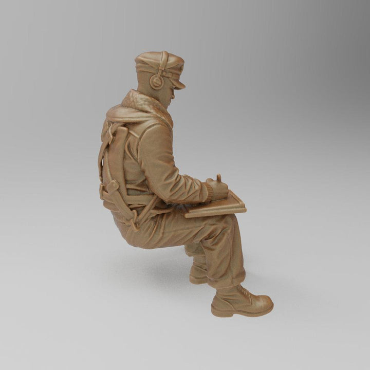 Unpainted terracotta-colored 3D printed miniature of a seated WW2 bomber navigator writing on a clipboard.