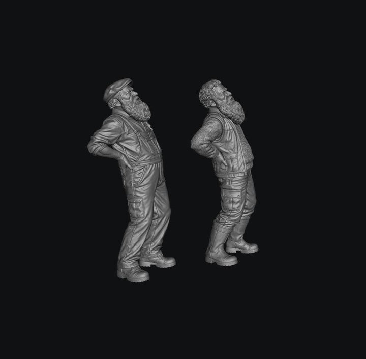 Two unpainted grey resin 3D-printed miniature figures of elderly bearded men with back pain in workwear.
