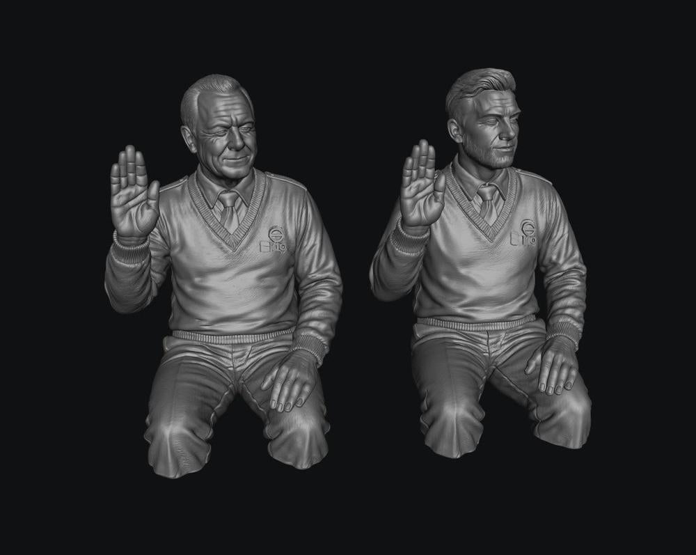 Two unpainted grey resin 3D-printed male bus driver figures in V-neck sweaters with hands raised in a greeting pose.