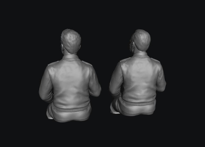 Two unpainted grey resin 3D-printed male bus driver figures shown from behind.