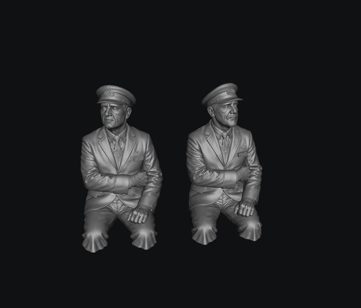 Two unpainted grey resin 3D-printed scale model train drivers wearing formal uniforms and peaked caps.