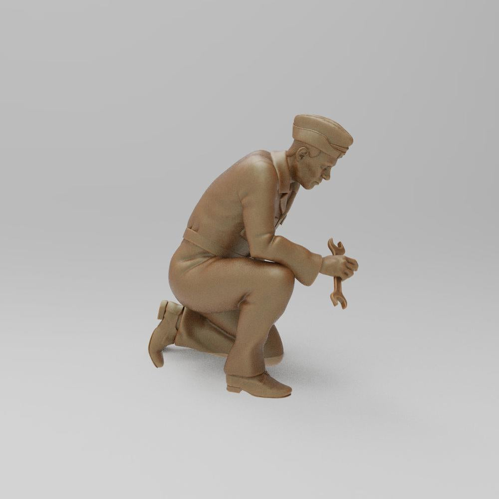 Unpainted terracotta resin 3D model of a kneeling WW2 RAF ground mechanic holding a wrench for diorama building.