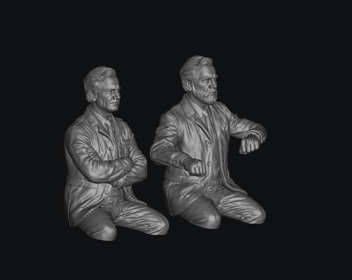 Two unpainted grey resin 3D-printed figures of early British Rail train crew members in seated poses.
