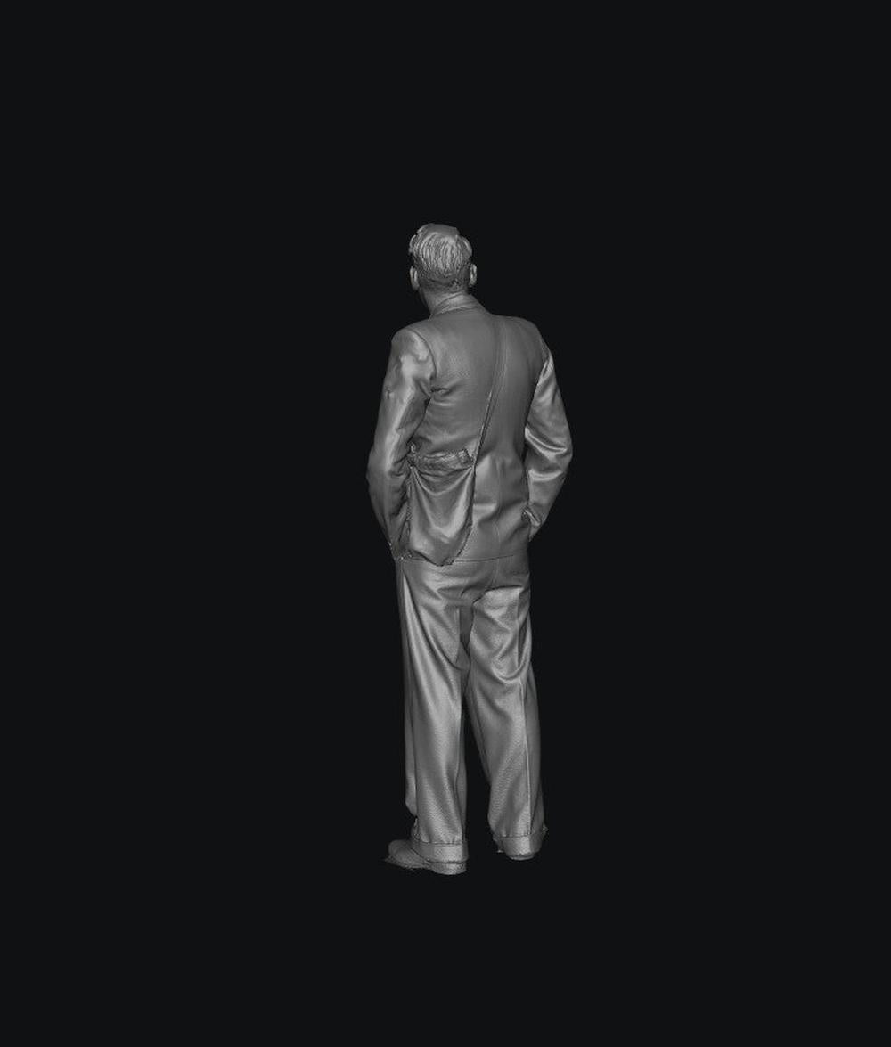 3D render of a grey resin 1940s male figure in a suit and satchel, standing in a rear view for scale modeling.