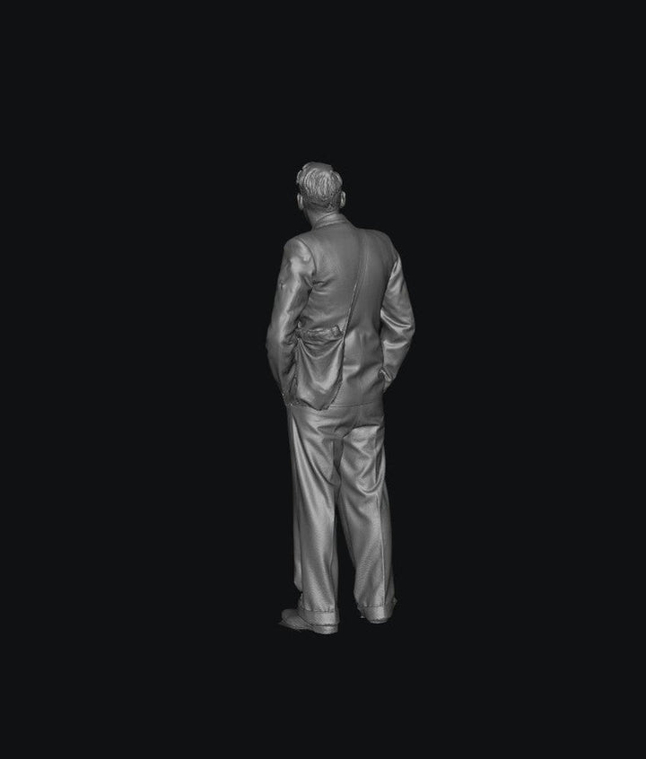 3D render of a grey resin 1940s male figure in a suit and satchel, standing in a rear view for scale modeling.
