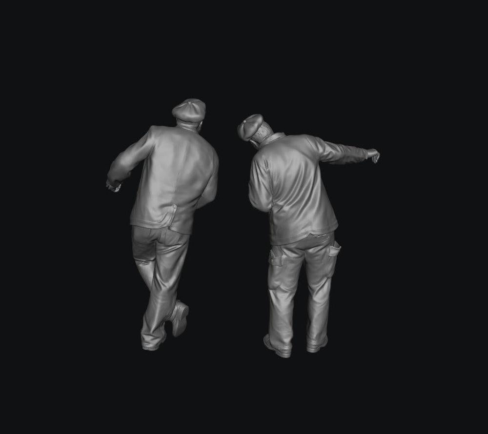 Two unpainted grey resin 3D-printed scale model train engine drivers wearing caps and jackets in standing poses.