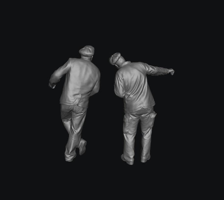 Two unpainted grey resin 3D-printed scale model train engine drivers wearing caps and jackets in standing poses.