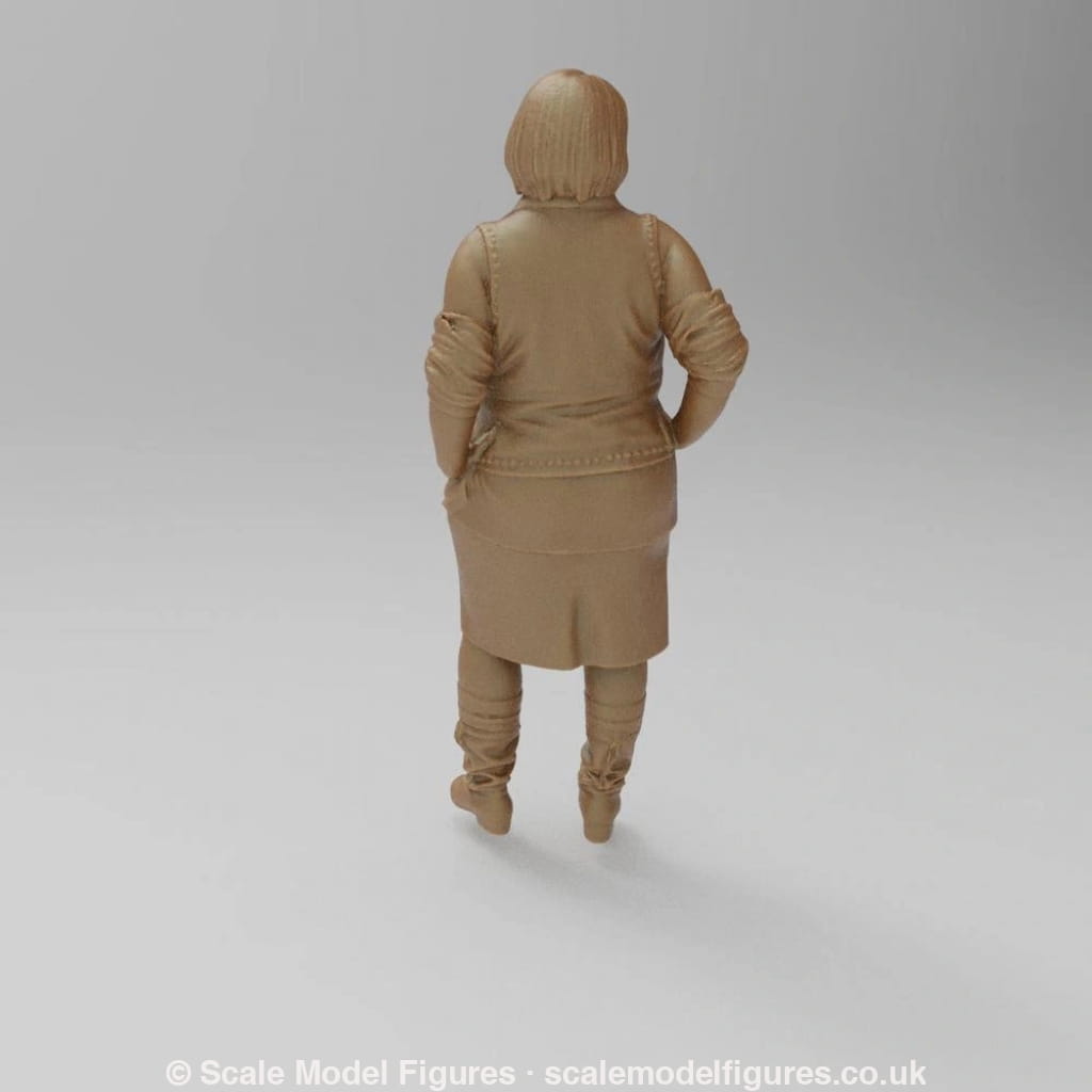 Unpainted terracotta-colored 3D resin scale model of a woman standing in a jacket, skirt, and boots, rear view.
